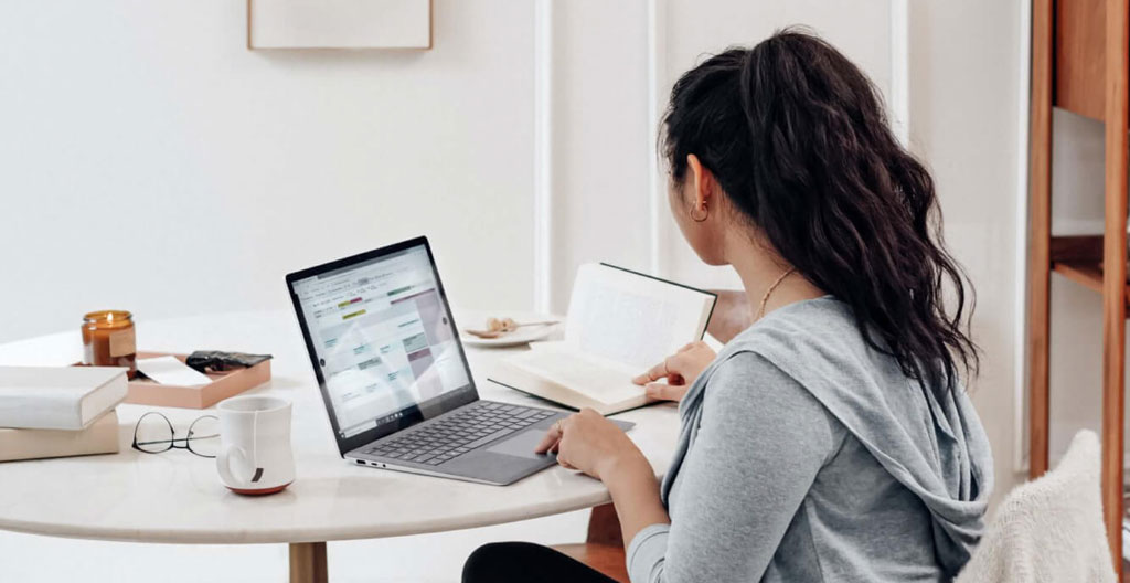 Gros plan sur des mains tapant sur un clavier d'ordinateur moderne avec un arrière-plan flouté de bureau contemporain