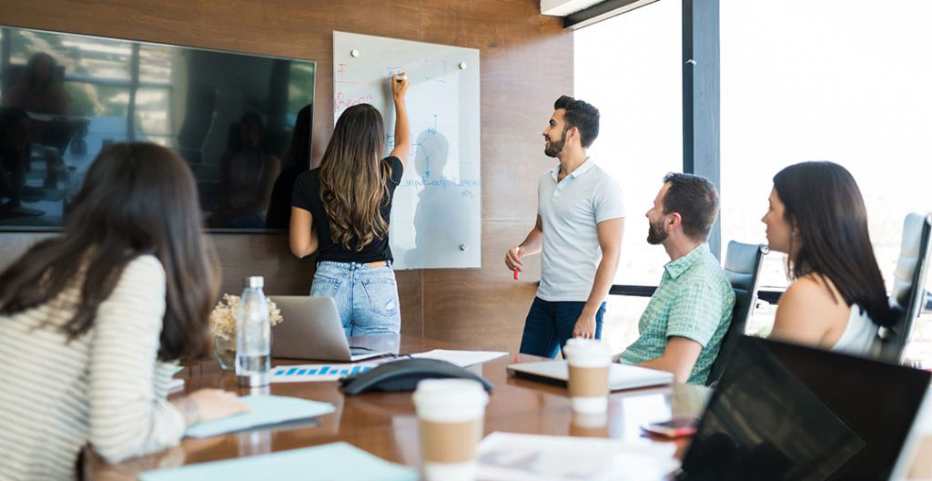Vue grand angle d'une salle de formation vide et contemporaine avec grandes baies vitrées, tables modernes et écrans muraux dans un style toulousain épuré